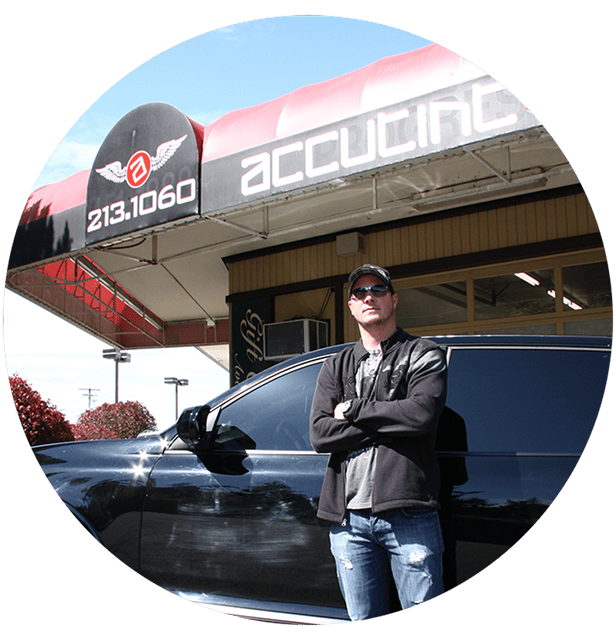 man posing with arms crossed in front of black SUV
