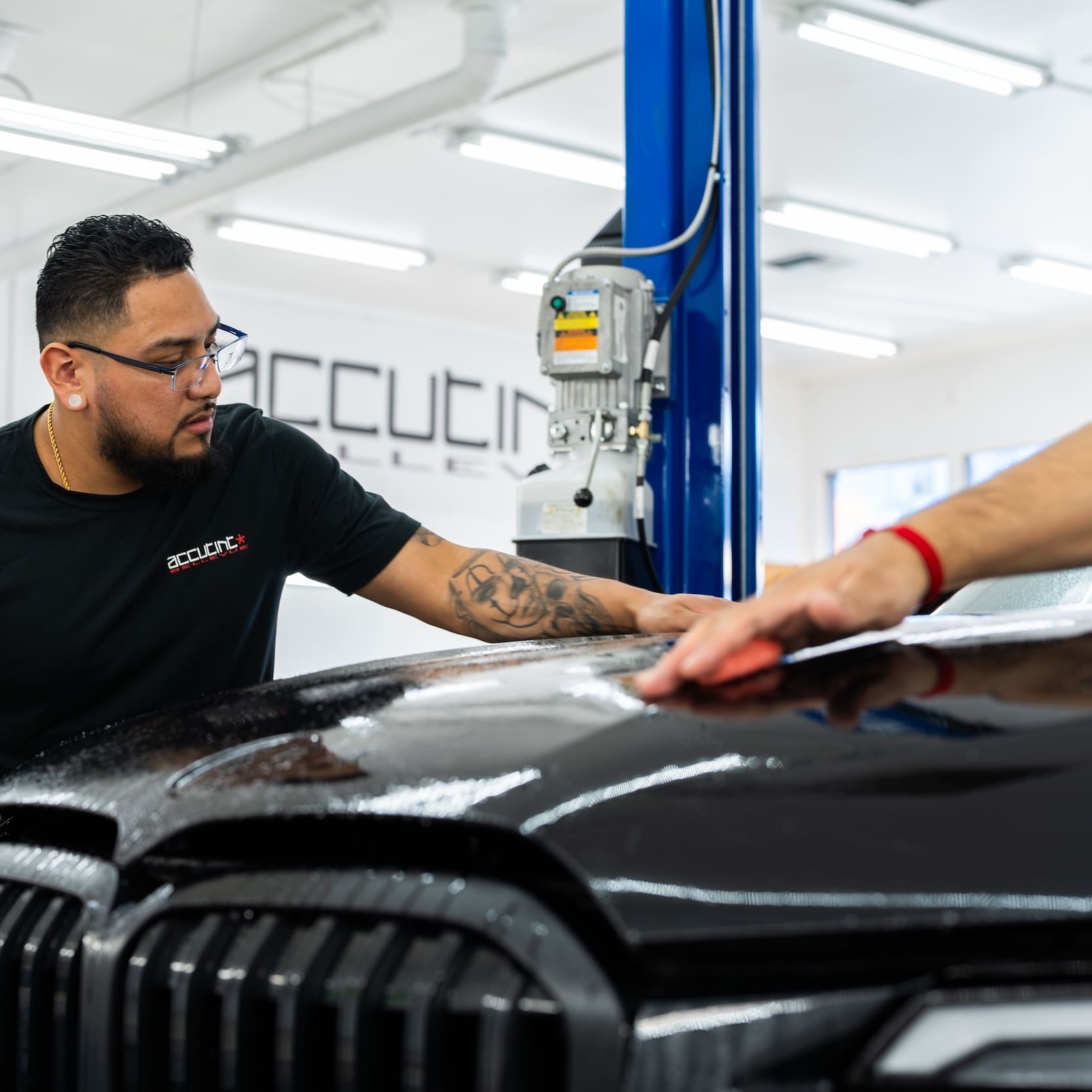 Applying clear film to hood of black car