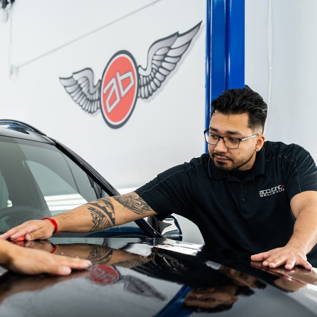 Applying clear film to hood of black car