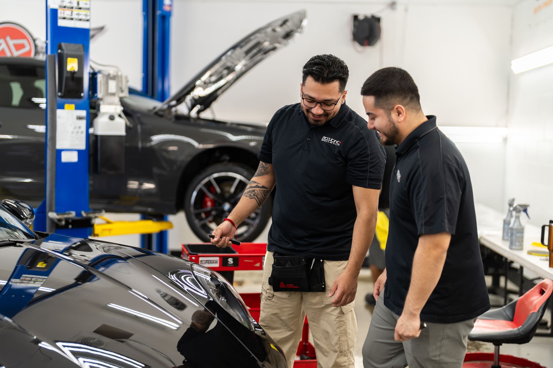 Two guys working on a black sports car