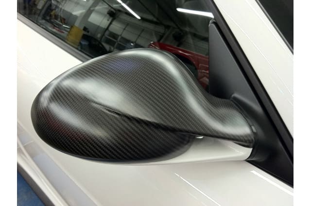 Black textured vinyl wrap on back of side mirror